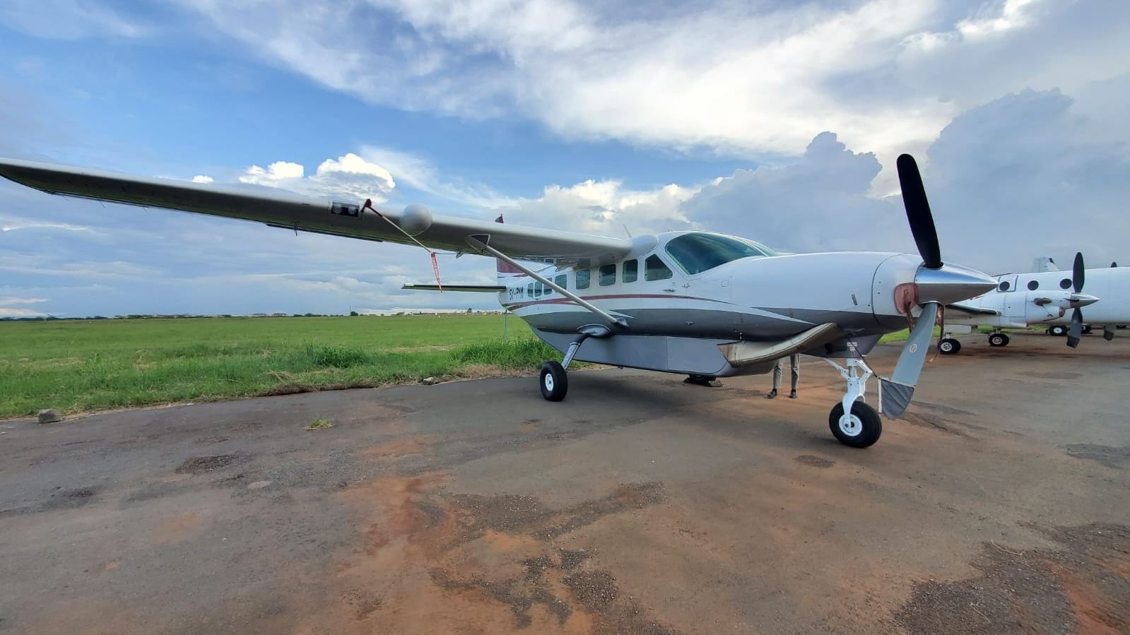 A Cessna Grand Caravan on the ramp under a dramatic East African sky